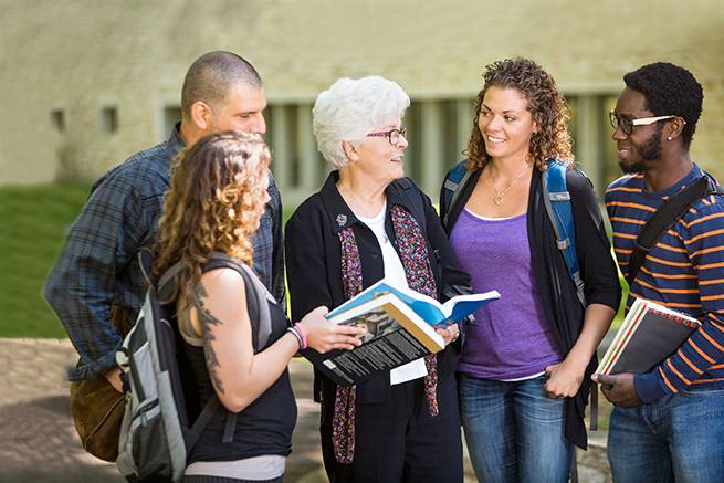 woman speaking with four college students