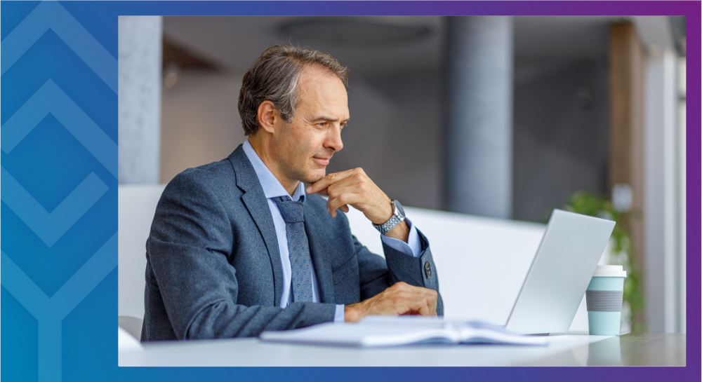 25-11-CLInfoWebinar-Cal A person sitting at a desk looking at a laptop