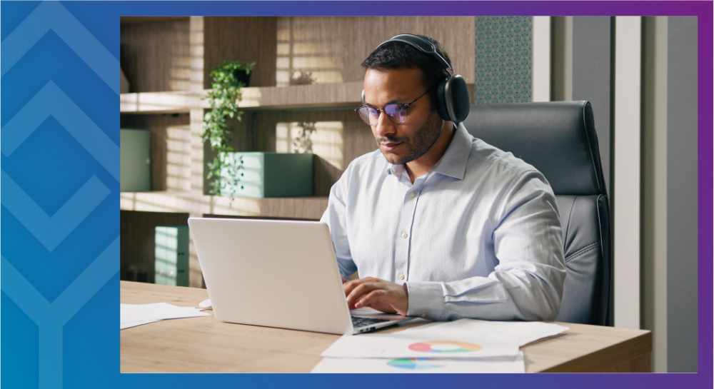 25-12-CLQAWebinar-Cal A person sitting at a desk looking at a laptop