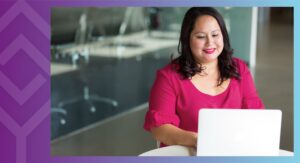 A person sitting at a table looking at a computer