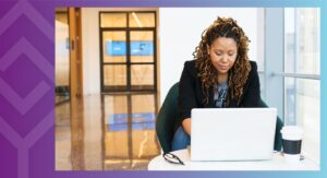 A person sitting at a table looking at a computer