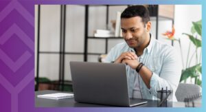 A person sitting at a table looking at a computer