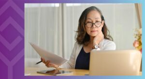 A person sitting at a table looking at a computer