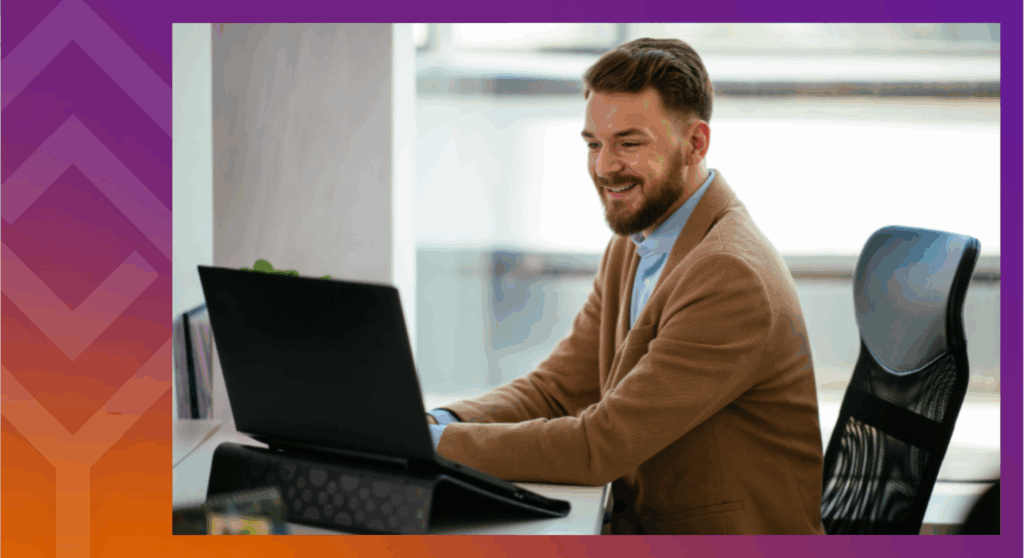 A person sitting at a desk smiling at a computer