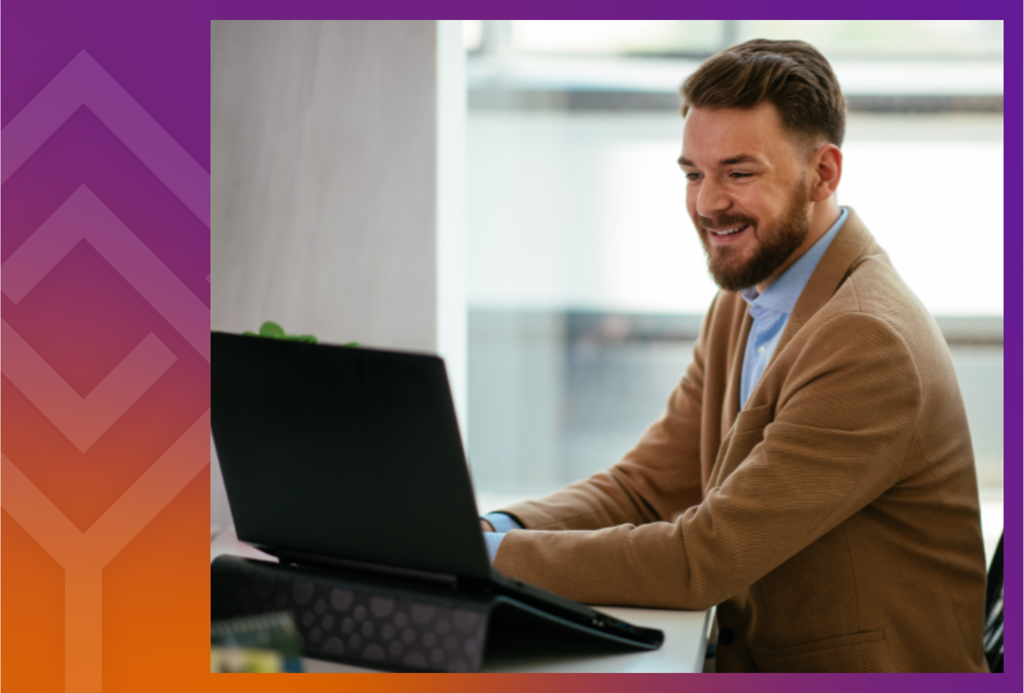 A person sitting at a desk smiling at a computer