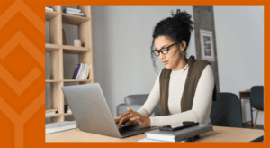 A person sitting at a desk looking at a laptop