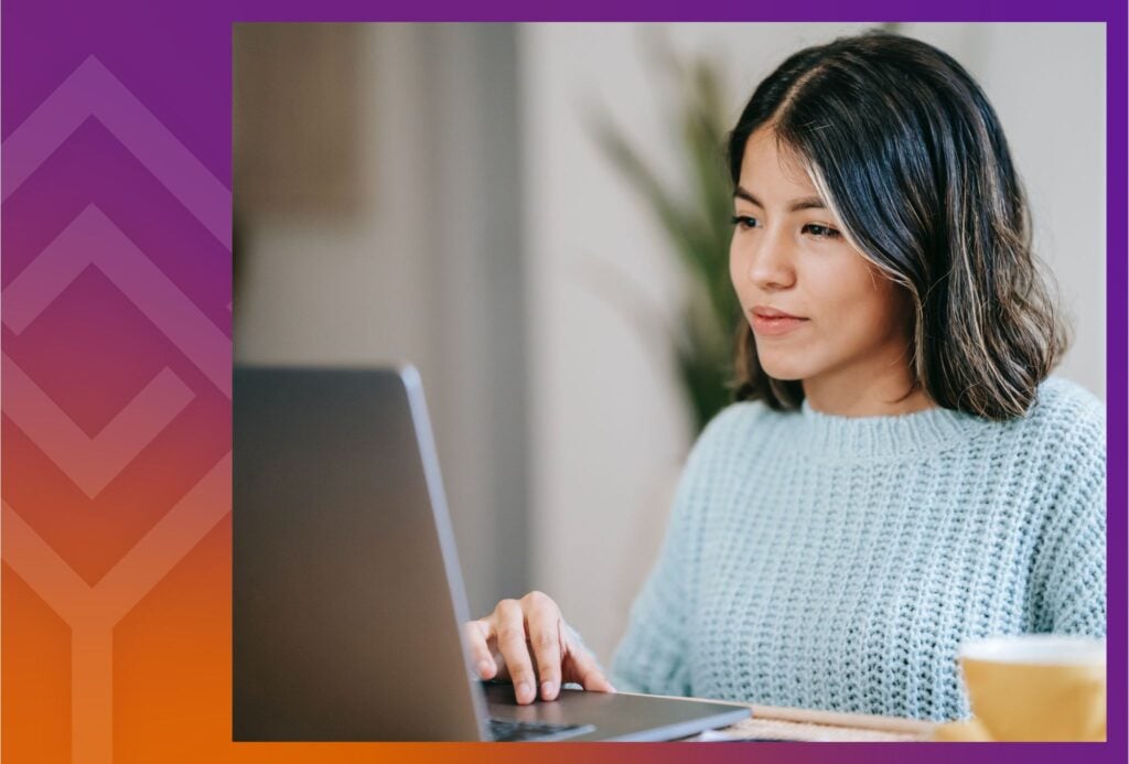 Person sitting at a desk looking at a laptop