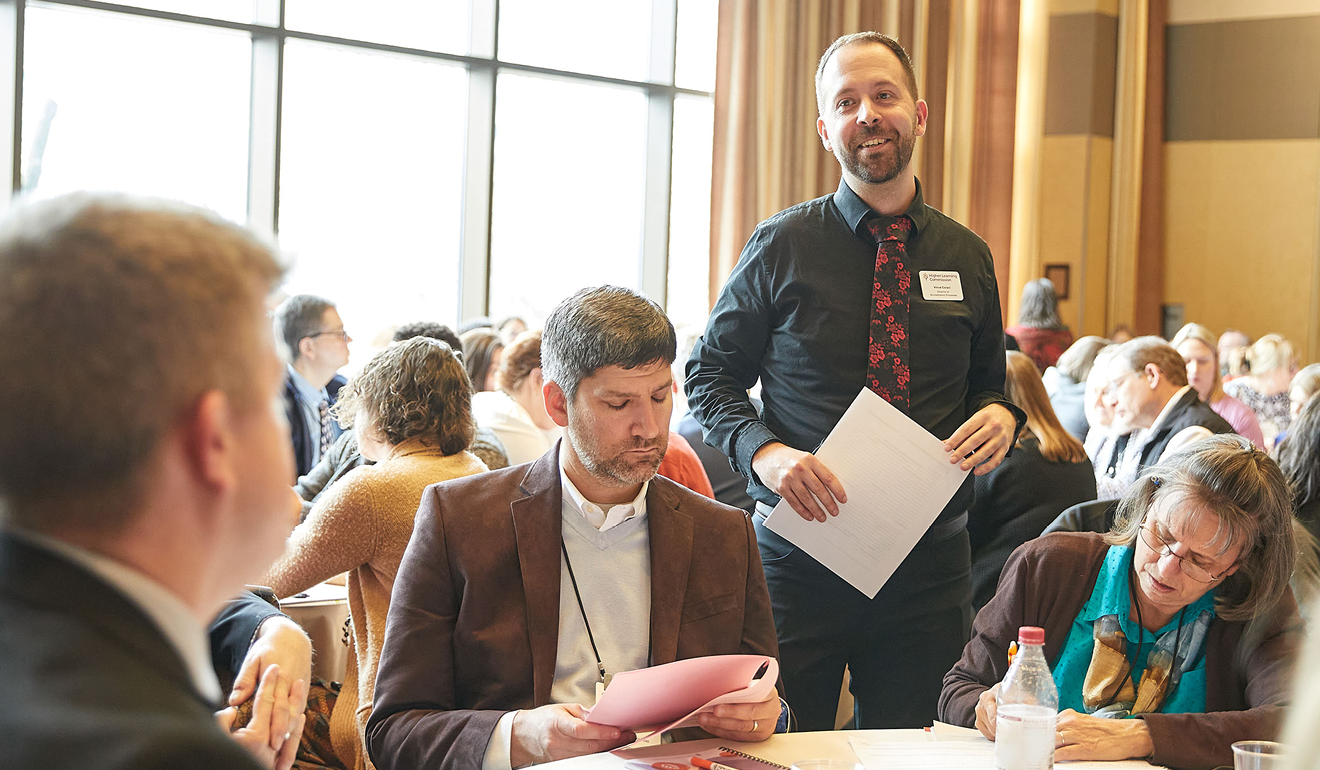 A person standing above people sitting at a table