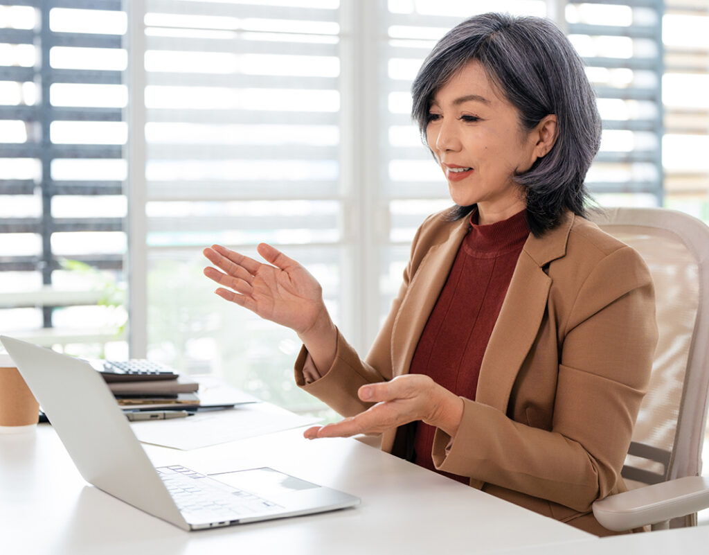 A woman at a computer attending a live webinar